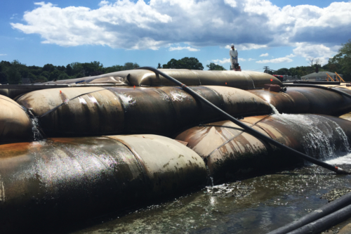 Active dewatering of stacked geotextile tubes